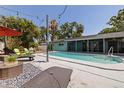 Inviting backyard pool area, perfect for relaxation, with stylish lounge furniture and tropical landscaping at 8401 Stillbrook Ave, Tampa, FL 33615