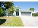 Charming single-story home with a well-maintained lawn, palm tree, and screened-in garage at 10321 Ravines Dr, New Port Richey, FL 34654