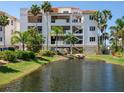 Condo exterior featuring an appealing pond, lush landscaping and convenient parking at 1042 Bellasol Way # 202, Apollo Beach, FL 33572