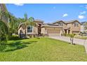 Inviting single-story home with lush green lawn, two car garage and desert landscaping at 10514 Scenic Hollow Dr, Riverview, FL 33578