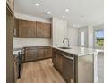 Modern kitchen with stainless steel appliances, wood cabinets, white backsplash, and center island at 10712 Oak Bend Dr, Parrish, FL 34219