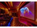 Home theater featuring tiered seating, projector, and large screen for immersive movie nights at 11296 Warm Wind Way, Weeki Wachee, FL 34613