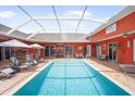 Inviting pool area with ample lounge seating, an outdoor kitchen, a bar, and a covered patio at 11296 Warm Wind Way, Weeki Wachee, FL 34613