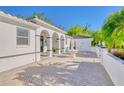 Side view of elegant estate featuring paved driveway with fountain and lush landscaping at 13483 Heritage Way, Sarasota, FL 34240