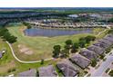 Aerial view showcases a community with a lake, golf course, and well-maintained landscaping at 1803 Pacific Dunes Dr, Sun City Center, FL 33573