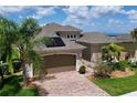 Charming single-story home featuring a brick driveway, two-car garage, and well-maintained landscaping at 1803 Pacific Dunes Dr, Sun City Center, FL 33573