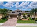 Charming single-story home featuring a brick driveway, two-car garage, and well-maintained landscaping at 1803 Pacific Dunes Dr, Sun City Center, FL 33573