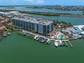 Beautiful waterfront condo building with a pool and boat docks on a sunny day at 202 Windward Psge # 304, Clearwater Beach, FL 33767