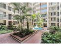 Beautiful courtyard with lush landscaping, fountain, and red brick pathways at 2699 Seville Blvd # 705, Clearwater, FL 33764