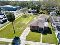 Aerial view of a charming home with a well-manicured lawn, mature trees, and a driveway at 318 Banana St, Tarpon Springs, FL 34689
