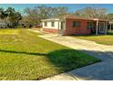 Charming brick home with a well-maintained lawn and a concrete driveway at 318 Banana St, Tarpon Springs, FL 34689