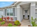 Inviting front entrance with a gray door, decorative wreath, and well-maintained landscaping at 3504 Golden Wheat Ln, Plant City, FL 33565