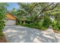 Home with a long driveway, mature trees, and lush greenery, offering a serene setting at 4215 Water Oaks Ln, Tampa, FL 33618