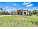 Well-manicured lawn leads up to the charming single-story home featuring a three-car garage at 4323 Baynes Rd, North Port, FL 34288