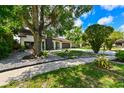 Well-maintained front yard with shade trees, landscaped with decorative rock, and lush greenery at 4520 Wescott Ln, Tampa, FL 33624