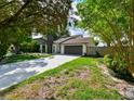 Well-maintained home featuring a long driveway, a front lawn with decorative rocks and lush greenery at 4520 Wescott Ln, Tampa, FL 33624