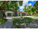 Single-story home with a manicured front lawn, lovely landscaping, and a two-car garage at 4520 Wescott Ln, Tampa, FL 33624