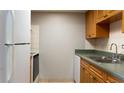 Kitchen featuring wooden cabinets, a stainless steel sink, white appliances, and neutral tiled floor at 4724 Michael Ct # 122, Tampa, FL 33614