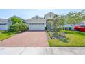 Inviting single-Gathering home with a brick driveway, lush lawn, and a two-car garage at 5548 Silver Sun Dr, Apollo Beach, FL 33572