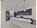 Sleek kitchen featuring stainless steel appliances, a spacious island with quartz counters and marble floors at 5548 Silver Sun Dr, Apollo Beach, FL 33572