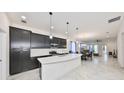 Modern kitchen with stainless steel appliances, a large island, and elegant pendant lighting at 5548 Silver Sun Dr, Apollo Beach, FL 33572