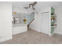 Bright living space with wood-look tile flooring, open to the kitchen and stairs, featuring stylish shelving at 6600 121St Ave # 4, Largo, FL 33773