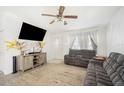 Comfortable living room with plush seating, modern entertainment center, and natural light from the window at 8004 N Brooks St, Tampa, FL 33604