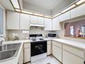 Bright kitchen featuring white cabinets, modern appliances, and a functional layout at 1003 Teal Pointe, Tarpon Springs, FL 34689
