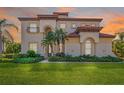 Stunning two-story home boasts a lush green lawn, mature landscaping, and a terracotta tile roof at 10528 Bermuda Isle Dr, Tampa, FL 33647