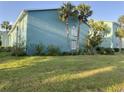 Two-story apartment building featuring lush landscaping, palm trees, and light green exterior at 11405 3Rd N St # 2, St Petersburg, FL 33716