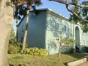 Two-story apartment building with light green exterior, surrounded by green grass and trees at 11405 3Rd N St # 2, St Petersburg, FL 33716