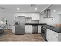 Modern kitchen featuring stainless steel appliances, sleek black countertops, and white cabinets, offering both style and functionality at 1276 Bertland Way, Clearwater, FL 33755