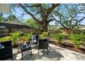 Relaxing outdoor patio space with stylish furniture, complemented by tropical landscaping and a serene backyard setting at 1276 Bertland Way, Clearwater, FL 33755