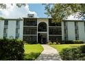 Multi-story condo building with balconies and landscaped lawn during a bright day at 1309 Pine Ridge E Cir # D3, Tarpon Springs, FL 34688
