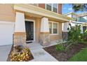 Close-up of a home's stone-accented front porch and doorway framed by manicured landscaping and a walkway at 15608 Starling Water Dr, Lithia, FL 33547