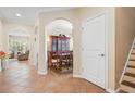 Hallway featuring arched doorways leading to the living room and dining room, with tile flooring and a staircase at 15608 Starling Water Dr, Lithia, FL 33547