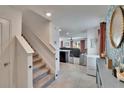 Bright foyer view features a carpeted staircase, tile flooring, and an open view to the living area at 16894 Delia St, Wimauma, FL 33598