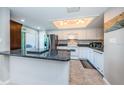 Bright kitchen featuring white cabinetry, granite countertops, stainless steel appliances, and tile flooring at 1806 Mariner Dr # 112, Tarpon Springs, FL 34689