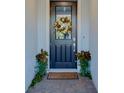Stylish front door adorned with a festive wreath, flanked by potted plants, and brick entryway at 19475 Bristol Wood Pl, Brooksville, FL 34601