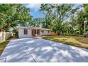 An inviting home featuring a long driveway, well-maintained lawn, and freshly painted exterior at 2106 W Saint Isabel St, Tampa, FL 33607