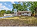 A cozy home with a spacious yard and a new driveway, all surrounded by mature trees at 2106 W Saint Isabel St, Tampa, FL 33607