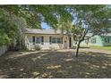Quaint single-story house with dark shutters, a well-kept lawn, and mature trees, showcasing its curb appeal at 249 41St Ne Ave, St Petersburg, FL 33703