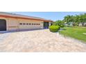 Paver driveway leads to a two-car garage and screened front entry at 2509 Locksley St # 237, Sun City Center, FL 33573