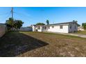 A spacious backyard featuring a well-maintained lawn and a charming white home with a classic design at 3706 Cambridge St, New Port Richey, FL 34652