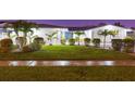 Charming single-story home showcasing a well-kept lawn, mature palm trees, and subtle landscape lighting at night at 4644 Bay Crest Dr, Tampa, FL 33615