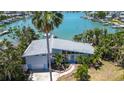 Waterfront home featuring modern architecture, lush landscaping, and private dock access at 712 Sunset Cv, Madeira Beach, FL 33708