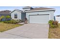 Exterior view of a home with a two-car garage, concrete driveway and manicured lawn at 7139 Steer Blade Dr, Zephyrhills, FL 33541