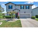 Charming two-story home boasts a gray exterior, manicured landscaping, and an attached two-car garage at 8226 Summer Brook Ct, Land O Lakes, FL 34638