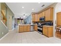Open-concept kitchen with stainless appliances, tile floors, and convenient access to living area at 8429 Hunters Fork Loop, Ruskin, FL 33573