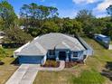 A captivating aerial view of this home's fresh roof, lush landscaping, and welcoming facade at 8604 Vicksburg Rd, Spring Hill, FL 34608